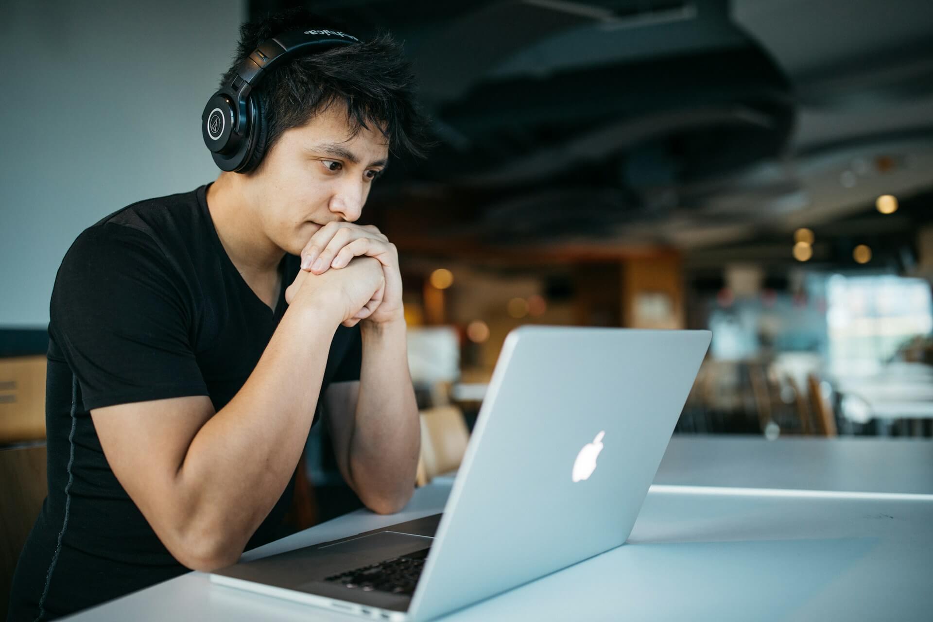 adult student studying on laptop with headphones