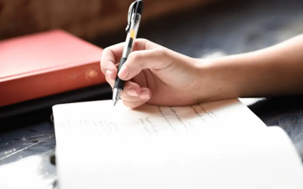 hand making notes in notebook